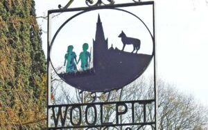 Woolpit, FOTO: Woolpit village sign by Adrian S Pye, CC BY-SA 2.0, via Wikimedia Commons