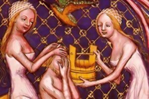 Three women with long hair sit around a yellow barrel, touching heads, in front of a purple lattice backdrop.