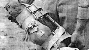 Person wearing a heavy metal leg brace with straps and hinges on the leg.