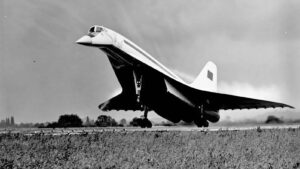 Jet aircraft lifting off from runway, wheels down, in a dramatic black-and-white photo.