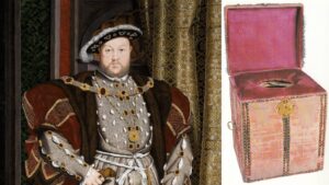 Portrait of a 16th‑century nobleman in ornate silver armor and fur-trimmed robe, beside a pink velvet storage chest with an open lid.